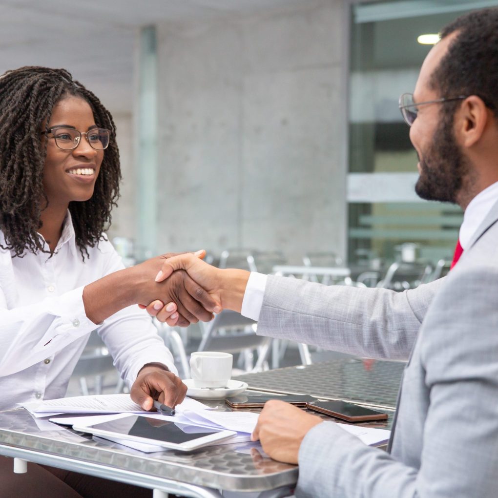 smiling-businesswoman-shaking-hands-with-partner (1)