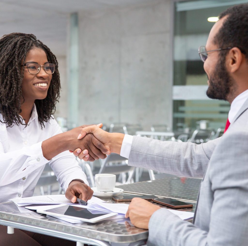 smiling-businesswoman-shaking-hands-with-partner (1)